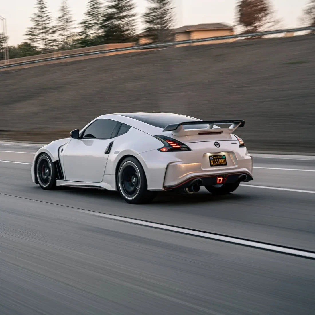 White Pearl Glitter Gloss vinyl wrap Nissan 370Z driving on a track.
