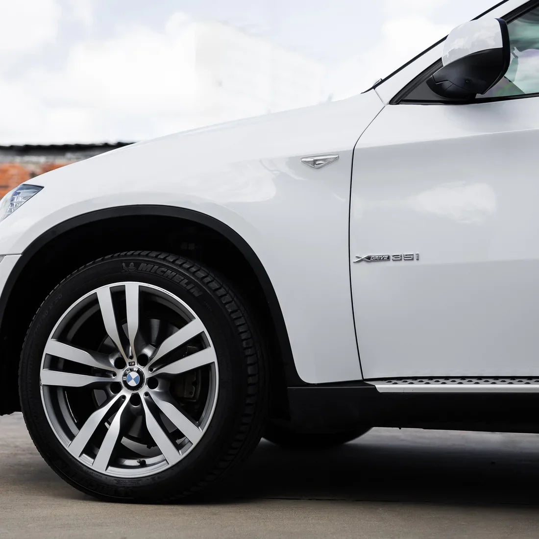 Close-up side view of frosted pearl white chameleon wrap on car