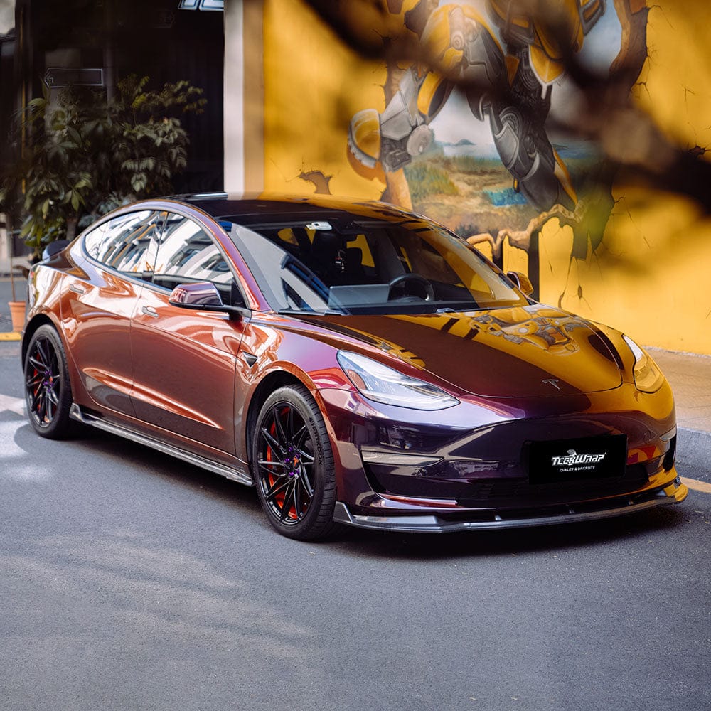 Front angle of Tesla wrapped in Madeira Red (RD17-HD) Chameleon Metallic Vinyl, showcasing dramatic color shifts from rich burgundy-purple to vivid metallic red in sunlight.
