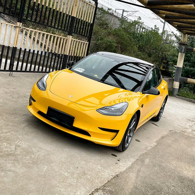 Tesla front angled view in Yellow high gloss ultra cab taxi vinyl finish.