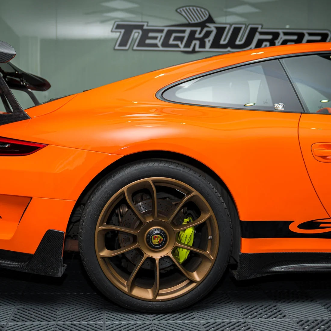 High Gloss Tangerine Orange Vinyl Wrap on Porsche Wheel Close-Up
