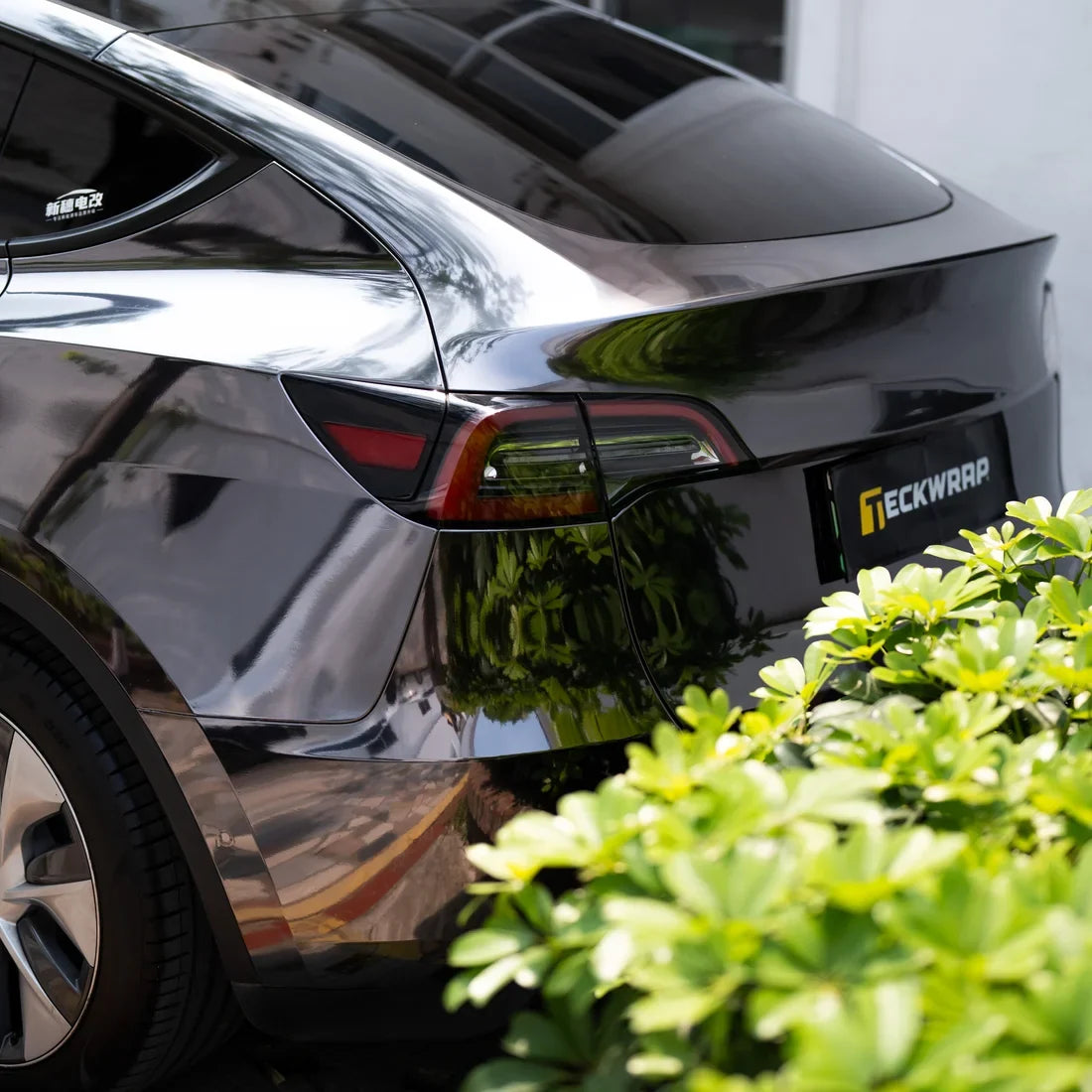 Black Tesla featuring a glossy Jet Black Mirror Chrome vinyl wrap.