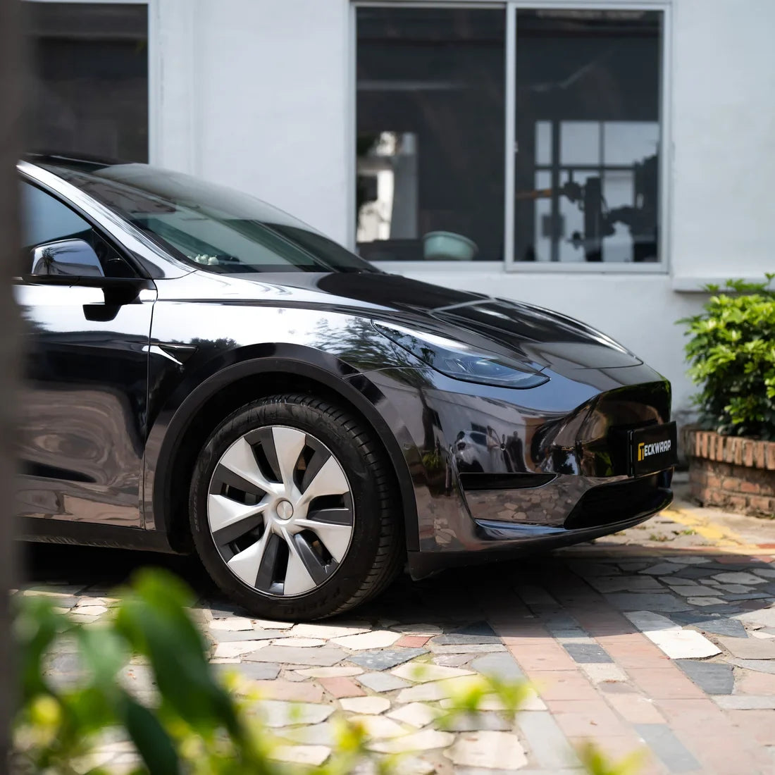 Jet Black Mirror Chrome vinyl wrap Tesla with a polished black exterior.