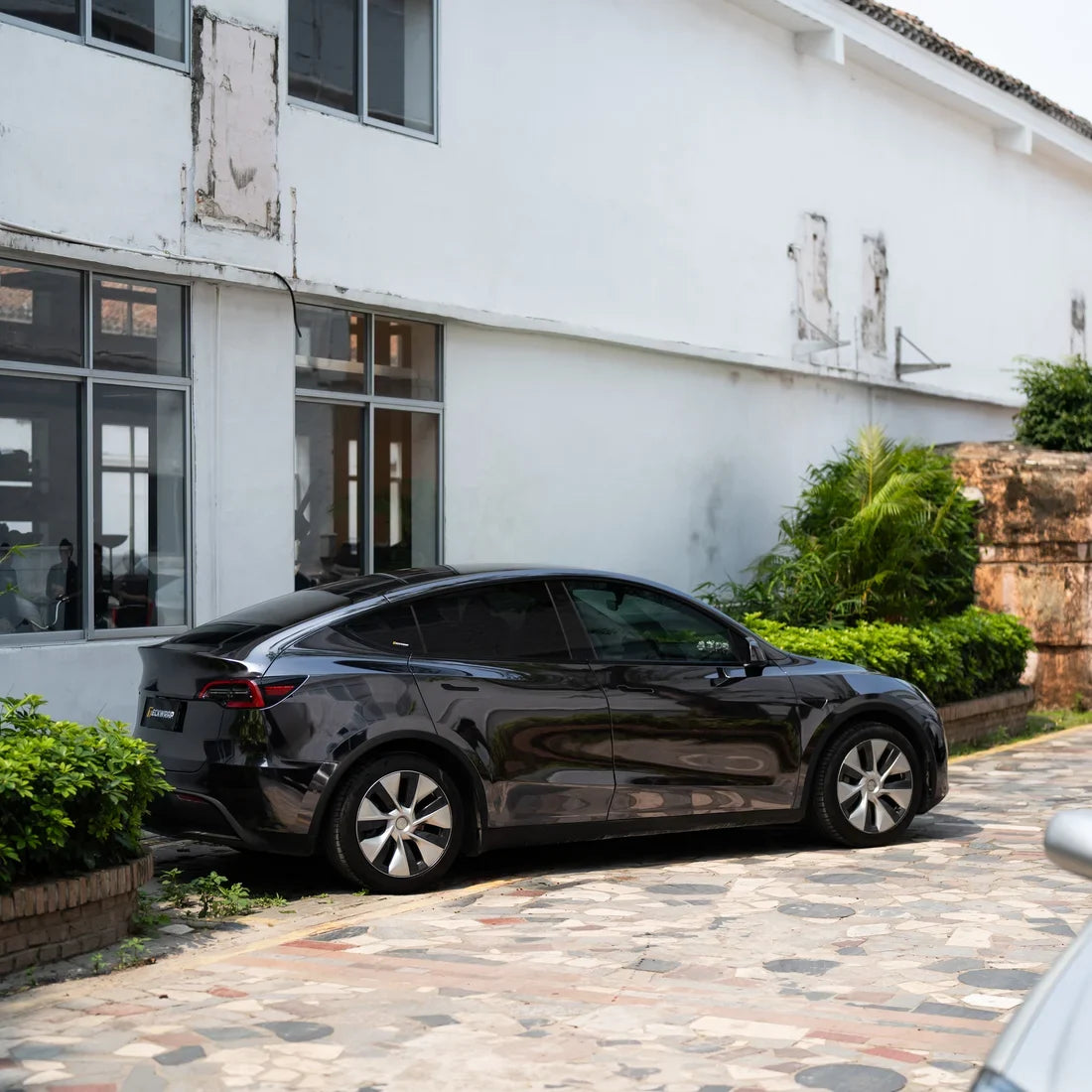 Black Tesla with a mirror-like Jet Black Chrome vinyl wrap finish.