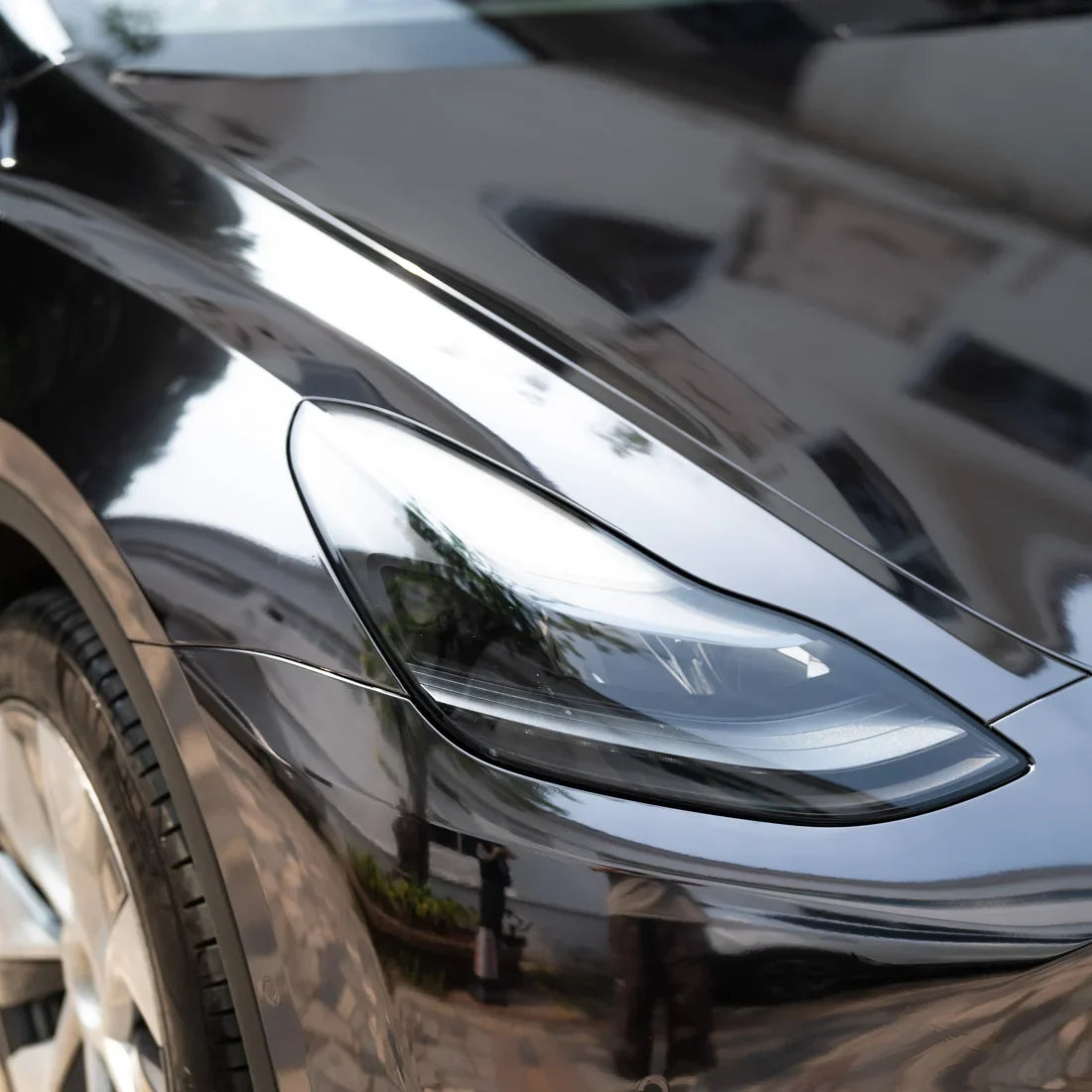 Jet Black Mirror Chrome vinyl wrap Tesla with a dark metallic body finish.