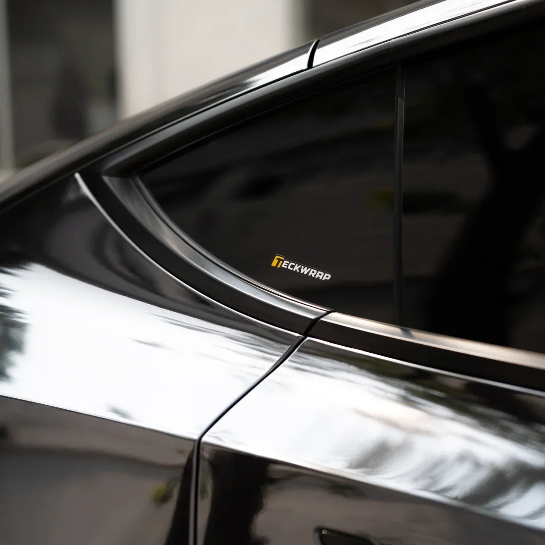 Jet Black Mirror Chrome vinyl wrap Tesla reflecting light across its dark exterior.