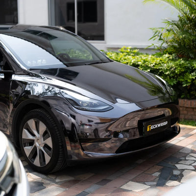 Black Tesla displaying a smooth Jet Black Mirror Chrome vinyl wrap finish.