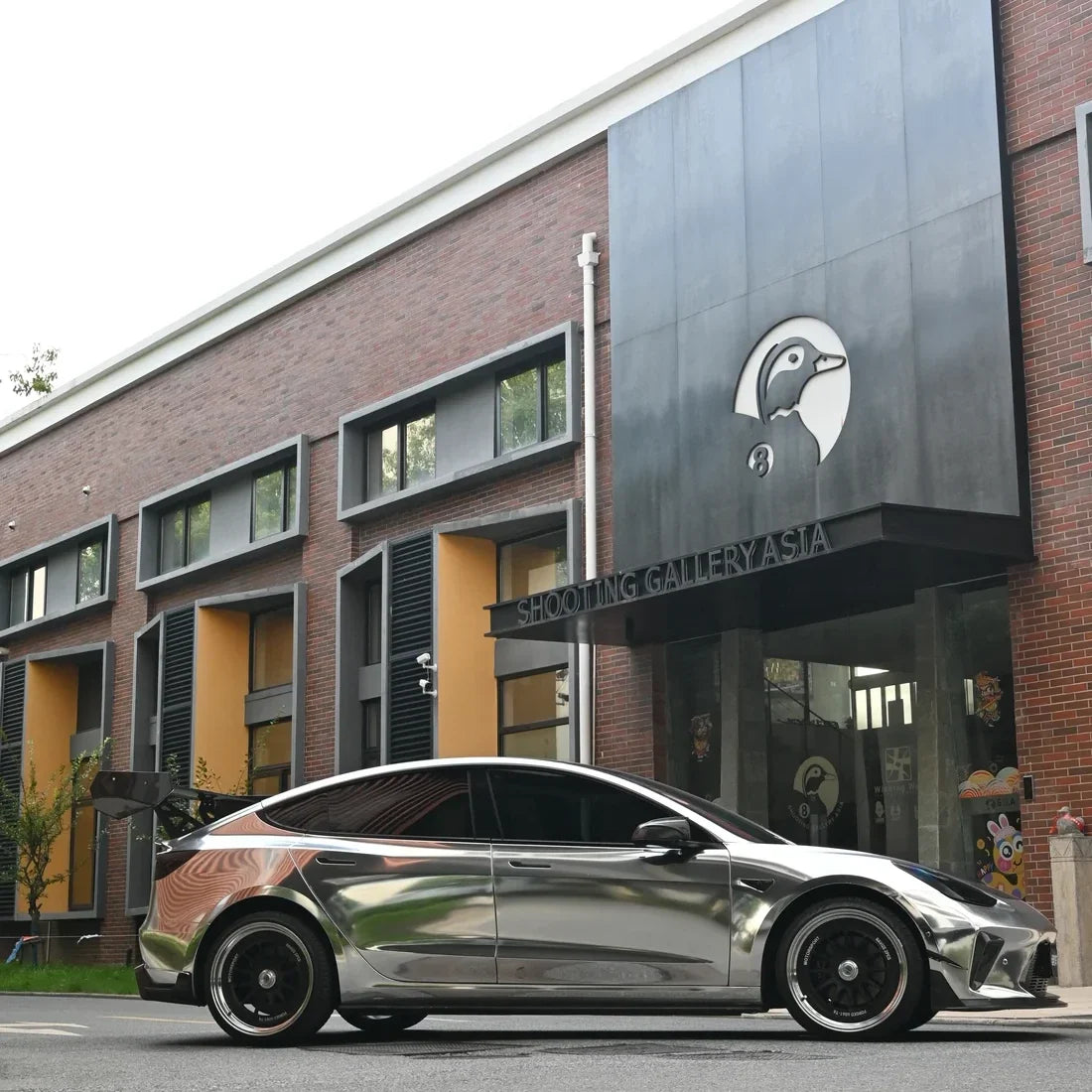 Jet Black Mirror Chrome Tesla highlighting its reflective carbon-look vinyl wrap.