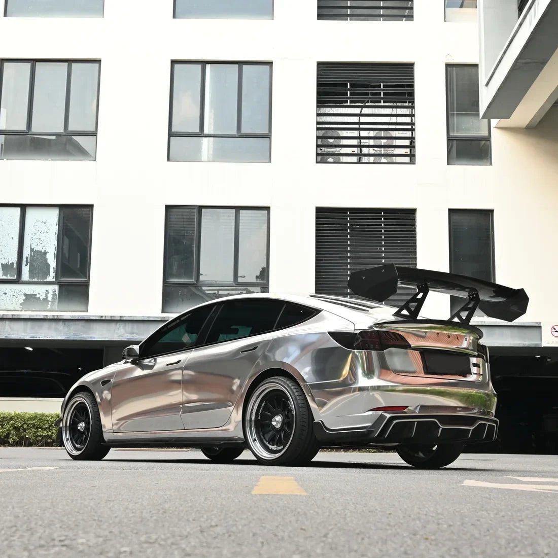 Tesla displaying a deep Jet Black Mirror Chrome carbon vinyl wrap finish.
