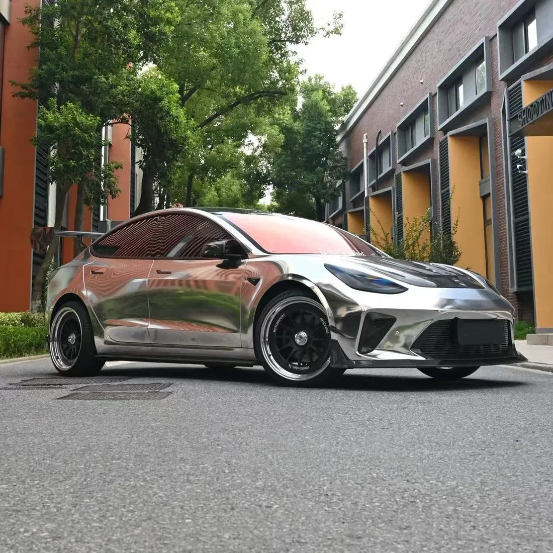 Jet Black Mirror Chrome vinyl wrap Tesla with a glossy carbon-style finish.