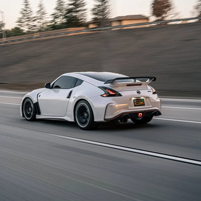 White Pearl Glitter Gloss vinyl wrap Nissan 370Z driving on a track.