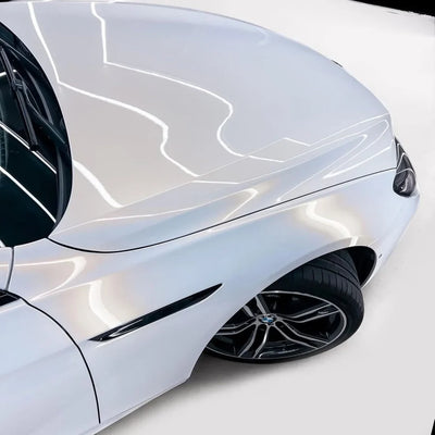 Close-up of a glossy gold pearl white chameleon car wrap on body