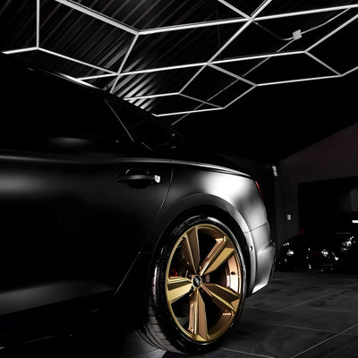 A close-up of a matte black car wheel and fender