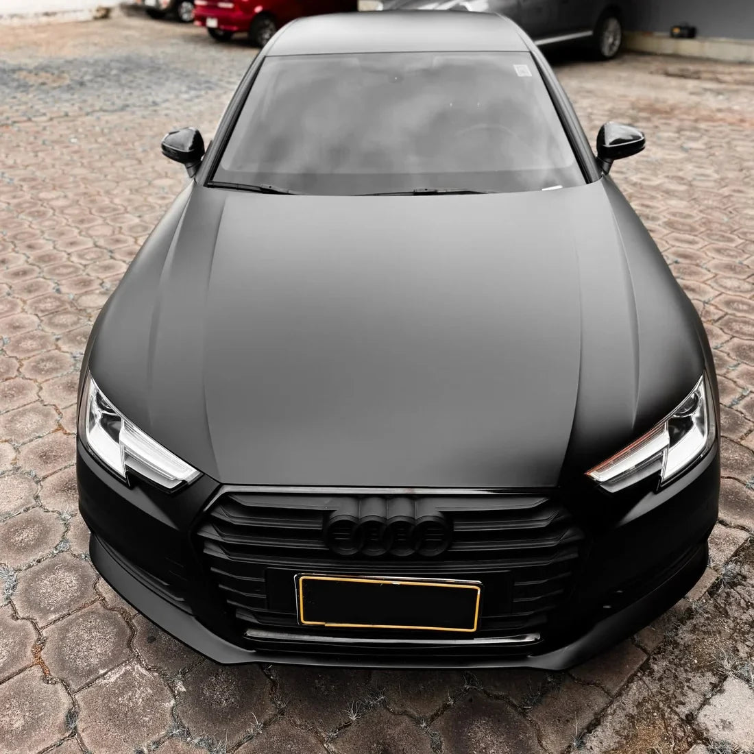 A matte black car wrap applied to an Audi sedan