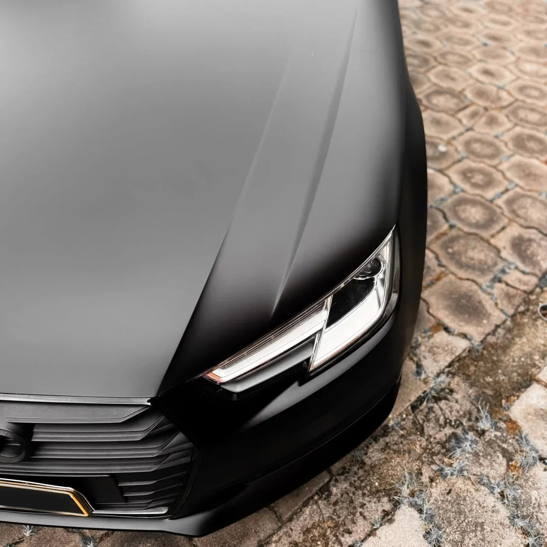 Close-up of Matte Black Vinyl Wrap on Audi headlight