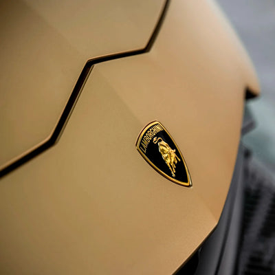 Satin Metallic Imperial Gold Vinyl Wrap on Lamborghini Urus hood logo
