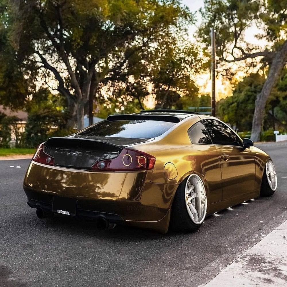 a sports car elegantly wrapped in TeckWrap Gloss Black Gold Vinyl Wrap