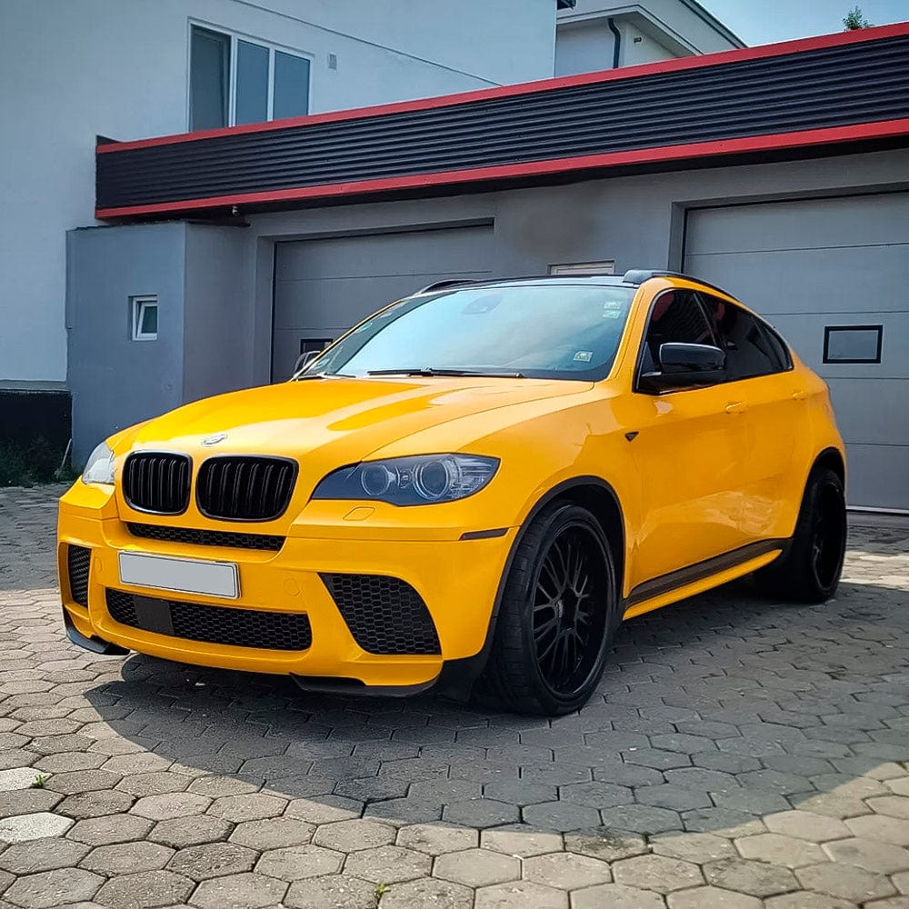 Bold and striking BMW X6 SUV wrapped in TeckWrap's glossy Golden Yellow (RB25-HD), standing out prominently on a driveway.